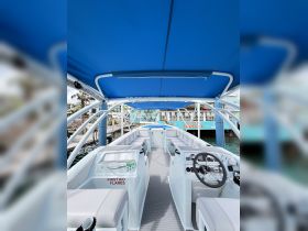 A clean and spacious interior view of a boat's helm and seating area, showcasing the comfortable layout and essential equipment for a smooth sailing experience.