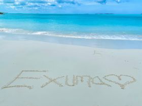 A beautiful beach scene in Exuma, featuring the name 'Exuma' written in the sand, with stunning turquoise waters in the background — a perfect representation of paradise.
