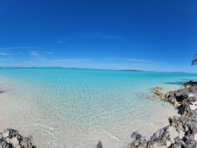 A stunning view of crystal-clear turquoise waters and a serene beach, perfect for showcasing the natural beauty of tropical destinations.