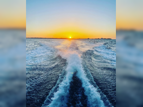 A stunning sunset view over the water, showcasing the beautiful wake created by the boat — perfect for capturing the essence of a serene evening on the water.