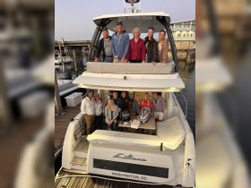A joyful group gathers on the deck of the 'Liliana' in Washington, DC, celebrating together — perfect for family gatherings or special occasions on the water.