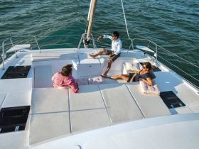 A group of friends enjoys a relaxing moment on the deck of a catamaran, soaking up the sun and the beautiful ocean views — perfect for a day of leisure on the water.