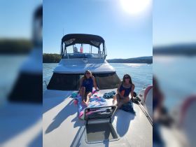 Two friends enjoy a relaxing day on the deck of a boat, soaking up the sun and making memories on the water.