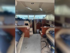 A cozy interior view of a boat cabin featuring comfortable seating and a well-equipped helm area, perfect for relaxing during your maritime adventures.