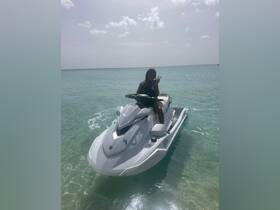 A person enjoys riding a jet ski in crystal-clear waters, showcasing the thrill of water sports and adventure on the ocean.