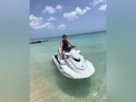 A young man enjoys a thrilling ride on a jet ski in crystal-clear waters, perfect for adventure seekers looking to explore the ocean.
