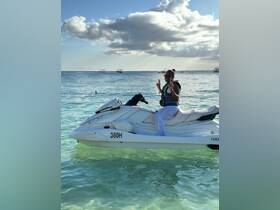 A joyful individual poses on a jet ski in clear waters, showcasing the thrill of water sports and adventure on the ocean.
