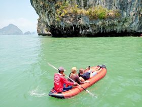 A group enjoys a kayaking adventure in serene waters, surrounded by stunning rock formations — perfect for exploring nature and creating unforgettable memories.