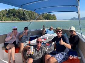 A cheerful group enjoys a sunny day on the boat, celebrating with drinks and smiles — perfect for a fun outing on the water.