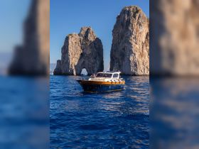 A beautiful boat navigates the stunning waters near iconic rock formations, showcasing the perfect blend of nature and maritime adventure.