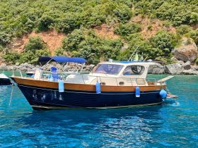 A beautiful yacht anchored in clear turquoise waters, surrounded by lush greenery — perfect for a serene day on the water.