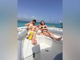 A cheerful couple enjoys drinks and snacks on a boat under the sun, capturing the essence of a perfect day on the water.