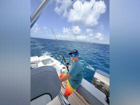 A young boy enjoys a fishing trip on a boat, showcasing the excitement of ocean adventures and family bonding on the water.