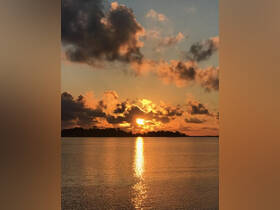 A stunning sunset casts a golden reflection on the water, creating a serene atmosphere perfect for evening boat cruises.