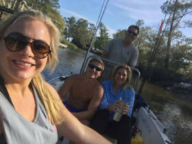 A cheerful group of friends enjoys a day on the water, capturing memories aboard their boat — perfect for fishing trips and outdoor adventures.