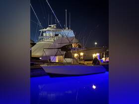 A stunning night view of a luxurious yacht docked at the marina, showcasing its sleek design and illuminated surroundings.