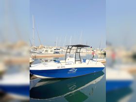 A sleek speedboat named 'Aqua Sports' docked in a marina, showcasing its vibrant blue hull and modern design — perfect for water adventures.
