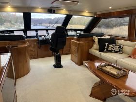 A well-appointed helm area inside a luxury yacht, featuring modern controls and comfortable seating, perfect for navigating scenic waterways.
