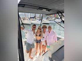 A cheerful group poses together on a boat, capturing a memorable moment amidst a vibrant marina backdrop — perfect for family outings or celebrations on the water.