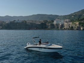 A scenic view of a boat cruising along the coastline, showcasing the beautiful landscape and clear waters — perfect for exploring coastal destinations.