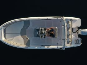 An aerial view of the helm and seating area inside a boat, showcasing the modern console and comfortable seating for an enjoyable boating experience.
