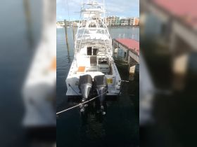 A clear view of a yacht docked at the marina, showcasing its sleek design and powerful outboard motors — perfect for fishing or leisure cruises.