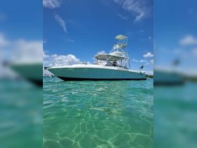 A sleek speedboat glides through crystal-clear waters under a bright blue sky, showcasing its elegant design and perfect for thrilling adventures on the water.