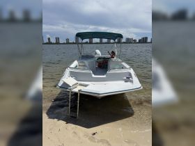A woman relaxes on the deck of a boat at the waterfront, enjoying the scenic view of the skyline — a perfect spot for leisure and relaxation on the water.