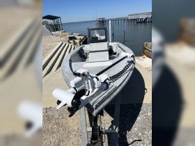 A close-up view of a fishing boat equipped with a Minn Kota motor, docked at a serene waterfront, ideal for fishing adventures.