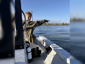 A young boy enjoys a day of fishing on a boat, pointing out to the water — a perfect moment capturing the joy of outdoor adventures.