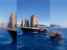 A beautiful boat navigates the stunning waters near iconic rock formations, showcasing the perfect setting for a day on the water.