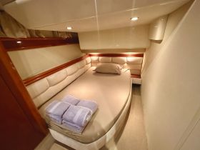Cozy cabin interior featuring a comfortable bed and neatly arranged towels, perfect for relaxing on a boat getaway.