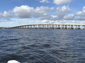 A scenic view of a bridge spanning over tranquil waters, showcasing the beauty of the landscape and perfect for capturing the essence of a boating adventure.