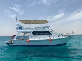 A stunning side view of a yacht cruising through clear turquoise waters, showcasing its elegant design and perfect for luxury charters.