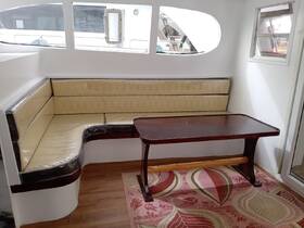 Cozy interior seating area of a boat featuring a comfortable lounge and dining table, perfect for relaxing or enjoying meals while on the water.