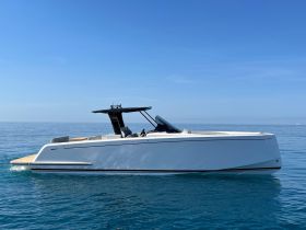 A sleek speedboat glides through calm waters under a clear blue sky, showcasing its modern design and elegance — perfect for thrilling water adventures.