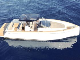 A stunning aerial view of a sleek speedboat gliding through deep blue waters, showcasing its elegant design and spacious deck, perfect for luxury outings.