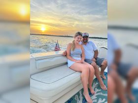 A couple enjoys a picturesque sunset on a boat, capturing a perfect moment of relaxation and celebration on the water.