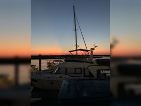 A serene sunset view of a yacht docked at the marina, showcasing the tranquil beauty of evening on the water.