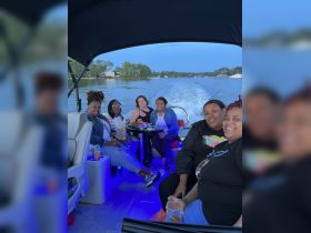 A lively group of friends enjoys drinks and snacks aboard a boat, creating unforgettable memories on the water.