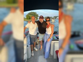 A cheerful group poses together on a boat, capturing a moment of fun and camaraderie on the water — perfect for summer outings and celebrations.