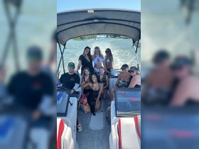 A lively group of friends enjoys a fun day on the boat, capturing memories and celebrating together on the water.