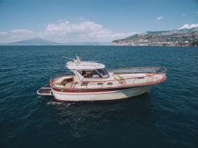 A stunning yacht glides through clear waters, showcasing its elegant design against a picturesque coastal backdrop.