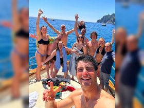 A lively group of friends celebrates on the deck of a boat, enjoying the sun and sea — perfect for summer parties and memorable outings.