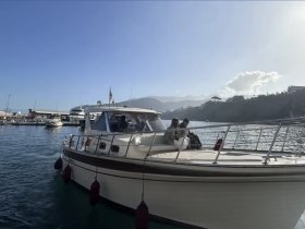 A couple enjoys a sunny day on a boat in the harbor, perfect for a relaxing getaway on the water.