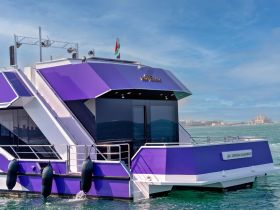 A striking purple yacht docked in calm waters, showcasing its modern design and elegant structure — perfect for luxury charters and private events.
