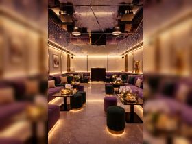 An elegant lounge area inside a boat, featuring plush seating and ambient lighting, perfect for relaxing and socializing while on the water.