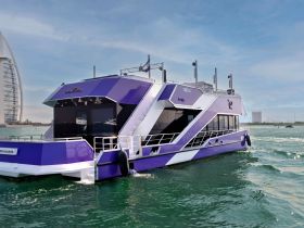 A sleek purple yacht cruising through clear waters, showcasing modern design and elegance, perfect for luxury outings.