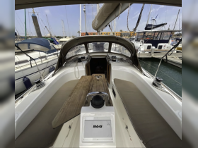Interior view of a well-equipped boat cabin featuring a spacious helm and comfortable seating, perfect for relaxing while cruising.