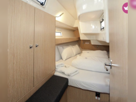 Cozy cabin interior featuring a comfortable double bed and storage space, perfect for relaxing on your boating adventures.